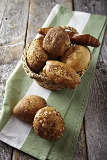 Diverse Bread Selection Prints: Various types of bread in a basket lying on a rustic table