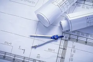 Construction Plan Blueprint Prints: Vertical version compass and rolled blueprints close up