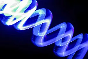 Blurred Motion Concept Image Prints: Vibrant blue neon light trails create dynamic patterns on a dark background