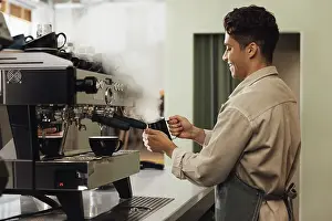 Hot Beverage Prints: Side view of a barista using a coffee machine