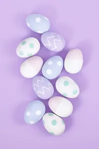 High Angle View Of Easter Eggs Prints: Top view of group of pastel colored easter eggs on violet background