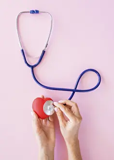 Heart Symbol Concept Prints: Top view hands checking heart with stethoscope