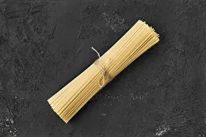 Italian Cuisine Image Prints: Top view of raw spaghetti on black background