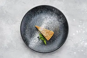 Bakery Products Still Life Prints: Top view of triangular piece of caramel cheese cake on a plate
