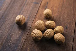 Wooden Table Background Prints: Walnuts shell on wooden table background