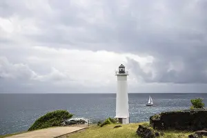 Dramatic Clouds Prints: White lighthouse on a steep coast