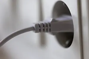 Energy Efficiency Concept Prints: White power plug in a socket on the wall