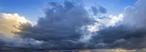 Dramatic Cloud Atmosphere Prints: A wide panoramic view of a dramatic cloudy sky with dark storm clouds
