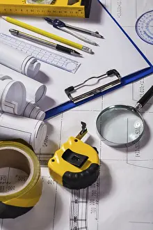 Deserted Construction Site Image Prints: Wiew on a typical engineer workplace with blueprint and measuring tools vertical