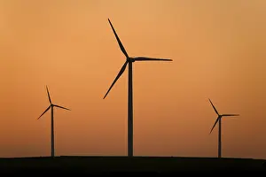Electricity Generation From Wind Prints: Three wind wheels in the sunset sky