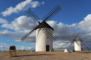 Castile La Mancha Landscapes Prints: Windmill in a rural setting under a blue sky with dramatic clouds