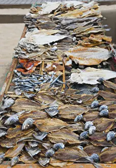 Dried Fish On Beach Prints: A wire rack with different types of dried fish on the beach