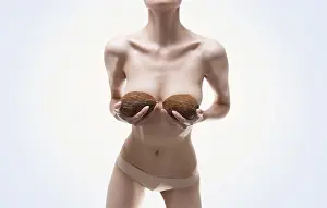Plastic Surgery Concept Prints: Woman posing in the studio with coconuts in her hands