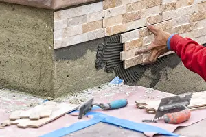 Masonry Work Prints: Worker installing wall tile at construction site