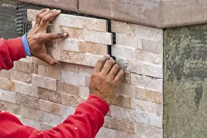 Swimming Pool Construction Prints: Worker installing wall tile at construction site