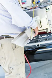 Seamless Rain Gutters Prints: Worker Measuring Rain Gutter Processing Through Seamless Shaping Machine