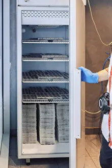 Industrial Building Architecture Style Prints: Worker opens refrigerator to store chocolates