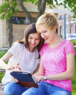 University Student Life Prints: Young college students using tablet computer while doing homework in the park