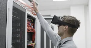 Server Room Background Prints: Young IT engeneer using virtual reality headset over server room background