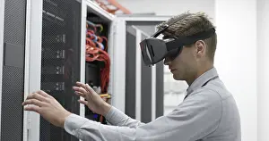 Server Room Background Prints: Young IT engeneer using virtual reality headset over server room background