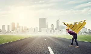 Young Construction Worker Prints: Young man builder carrying growing graph on his back