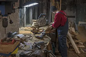 Evening Atmosphere Germany Prints: Young man working in his workshop in the evening