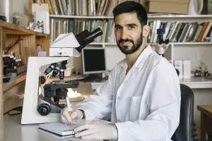 Scientist At Work Prints: Young scientist in front of microscope