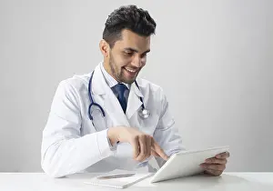 Medical Diagnosis Prints: Young smiling internist using tablet computer