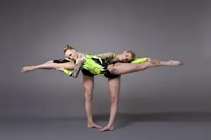 Fitness Wellbeing Exercise Prints: Two young woman as acrobats exercise pair program on grey